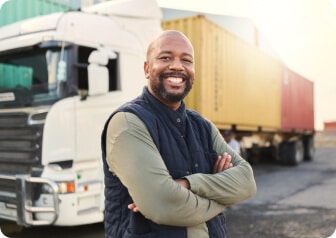 Man smiling towards camera with truck parked behind him